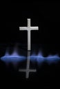 Cross or crucifix with reflection in the darkness. Burning fire flames Royalty Free Stock Photo