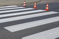 The cross-decorated pedestrian crossing with the still not dried out red. Restriction of traffic by road signs. Update road pedest Royalty Free Stock Photo