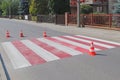 The cross-decorated pedestrian crossing with the still not dried out red. Restriction of traffic by road signs. Update road pedest Royalty Free Stock Photo