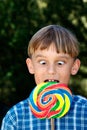 Cross eyed boy eating lollipop