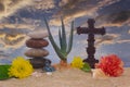 Christian Cross and Flowers on Sand With Aloe Vera Plant Royalty Free Stock Photo