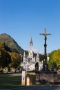 Cross in front of Sanctuary of Our Lady in Lourdes, France. Famous religious centre of pilgrims.