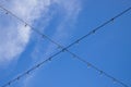 Cross garland wire against blue sky