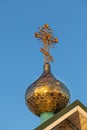 Cross and the golden dome of a Christian Orthodox church close-up against the blue sky on a sunny day Royalty Free Stock Photo