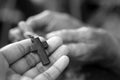 Cross in hand.  Hands holding Jesus Christ holy cross crucifix in black and white. Build a deeper relationship with God concept. Royalty Free Stock Photo