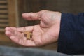 Cross in hand. Wooden small holy cross in senior Christian man hand closeup. In deep feeling of love, surrender and hope.