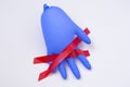 Red cross made of two pieces of insulating tape and blue rubber glove on white background Royalty Free Stock Photo