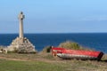 The cross and old broken wooden boat in the hill above the Saint-Gildas-Houat Port in Houat Island. Brittany, France