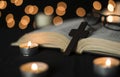 Cross with open bible with candles against bokeh lights background at night Royalty Free Stock Photo