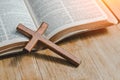 the cross over opened bible on wood table with window light Royalty Free Stock Photo