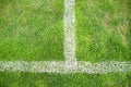 Cross of painted white lines on natural football grass. Artificial green turf texture. Royalty Free Stock Photo