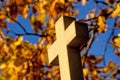 Cross of a pilgrim way with autumnal painted leaves