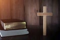 The cross is placed near A pile of bible books While there are candles that illuminate the Christian religious concept, the Royalty Free Stock Photo