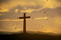 Cross religion symbol silhouette in grass over sunset or sunrise sky Royalty Free Stock Photo