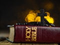 A cross and a rosary against the background of a holy bible on a wooden table in a church with lights from the light.The concept Royalty Free Stock Photo