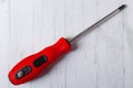 cross screwdriver with red handle on wooden background. Royalty Free Stock Photo