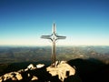 Cross with semi-precious stone raised at mountain summit in Alps. Sharp peak Royalty Free Stock Photo