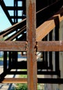 A cross shaped metal construct made of rusty angle sections connected by welding