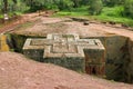 Cross-shaped Rock-hewn Church of Saint George surrounded by grass and trees in Lalibela, Ethiopia