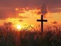 a cross silhouette standing in a field, with the warm glow of a sunset sky Royalty Free Stock Photo