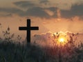 a cross silhouette standing in a field, with the warm glow of a sunset sky Royalty Free Stock Photo