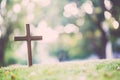 The cross standing on meadow sunset and bokeh background