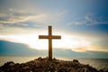 The cross standing on meadow sunset and flare background. Cross on a hill as the morning sun comes up for the day.