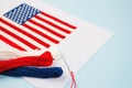 Cross stitch american flag with threads and needle on blue background. National symbolic of USA - flag Old Glory. Flag Day and Royalty Free Stock Photo