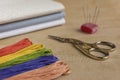 Cross-stitch kit for embroidery consisting of scissors, needles, multicoloured threads and canvas. Focus on the scissors. Royalty Free Stock Photo