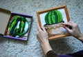 cross-stitch picture in hands cactus