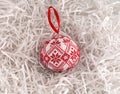 Cross stitched Christmas ornament on white shredded wrapping paper background. This Christmas ornament made by me Royalty Free Stock Photo