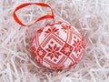 Cross stitched christmas ornament on white shredded wrapping paper background Royalty Free Stock Photo