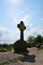 Cross on a stone base. The inscription on the cross in Old Church Slavonic. View of Lake Nero.