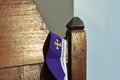 A cross symbol on a purple cloth for the priest is placed on a wooden platform for the confession of sins in Christianity