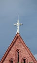 Cross on top of gable of church roof on blue sky background at cathedral of the holy trinity. Royalty Free Stock Photo