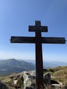 A cross on top of a mountain against a blue sky. A symbol of faith and hope outdoors. Sign of Christianity on a high mountain Royalty Free Stock Photo