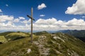 Cross on the top of a mountain with cloudy blue sky Royalty Free Stock Photo