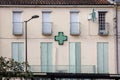 Pharmacy green cross lit with neon and LED lights in front of a French pharmacy, called pharmacie in France. Royalty Free Stock Photo