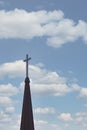 Cross up on the top of church steeple against cloudy sky in background Royalty Free Stock Photo