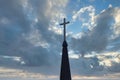 Cross up on the top of church steeple against cloudy sky in background Royalty Free Stock Photo