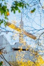 Cross on the white church roof and golden leaves in the foreground. White Cross against blue sky and white clouds, belive, hope,