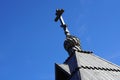 cross of a wooden church. Orthodoxy. Roof tiles. Closeup view. Onion dome chapel