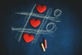 Cross zero of hearts and colored crayons on dark background Royalty Free Stock Photo