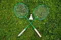 Crossed badminton rackets and shuttlecock on green grass, Badminton game, sport