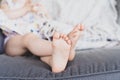 Crossed bare feet of anonymous little girl resting on couch