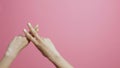 Crossed fingers of a girl on a pink studio background, hands showing a hashtag shape, concept social networks, indexing, a screens