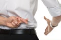 Crossed fingers at handshake Royalty Free Stock Photo