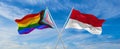 crossed flags of progress lgbt pride and Monaco flag waving in the wind at cloudy sky. Freedom and love concept. Pride month. Royalty Free Stock Photo