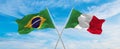 crossed national flags of Brazil and Italia flag waving in the wind at cloudy sky. Symbolizing relationship, dialog, travelling