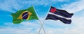 crossed national flags of Brazil and Leather, Latex and BDSM Pride flag waving in the wind at cloudy sky. Symbolizing relationship